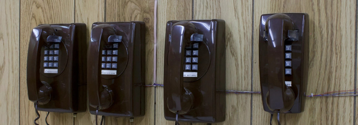 Old wall-mounted analogue telephone in a row