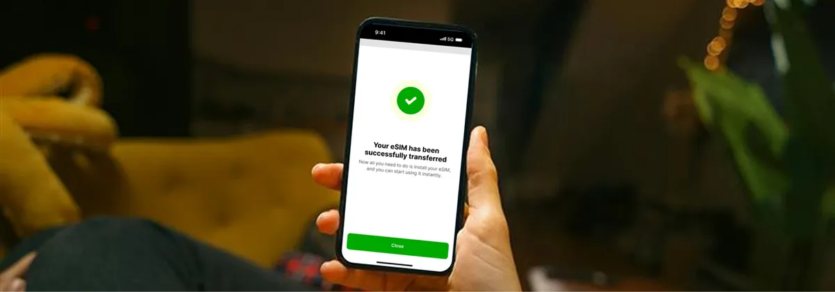 Hand holding an iPhone while the person transfers data on to this new device