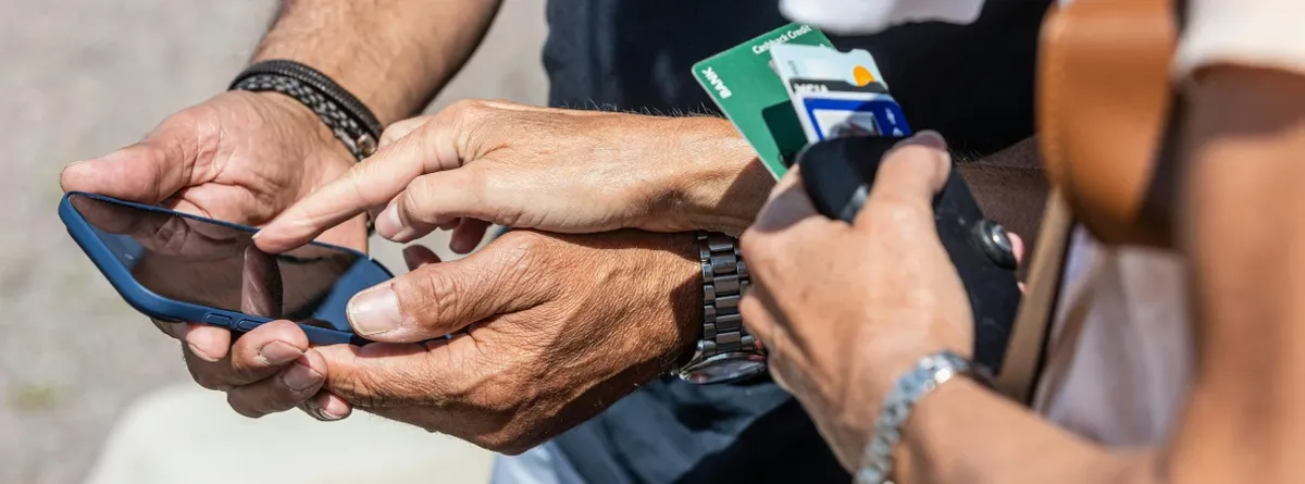 Travel eSIM what next - hands holding a mobile phone while another points at the screen