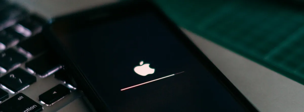 Apple for eSIM only markets - An iPhone loading with the Apple logo displayed, on top of a Macbook