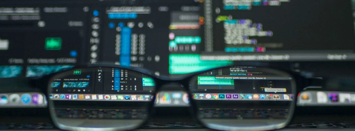 Risk Detection Compliance - glasses laid in front of monitors that display lots of data