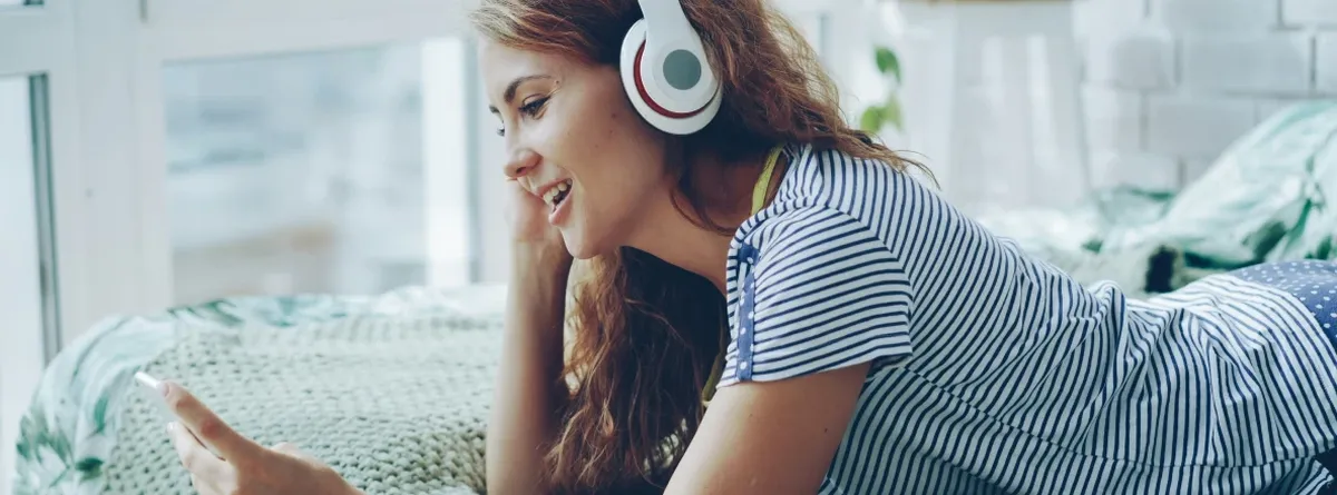 Ten Questions Customer Journey - a young woman using her mobile phone while lying on bed