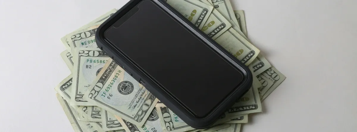 A smartphone on a pile of cash