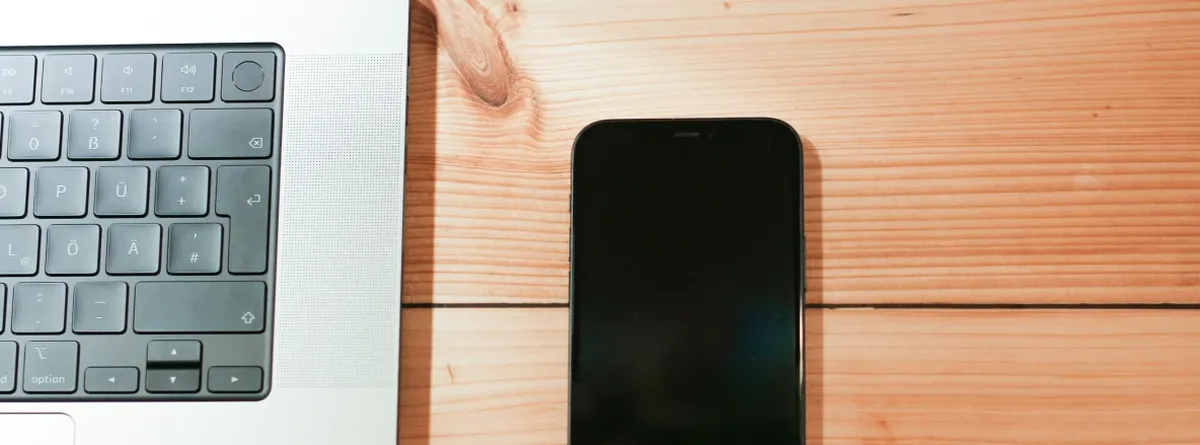 New Market, Local Presence - laptop and mobile phone on a brown wooden desk