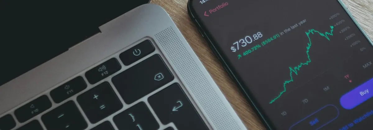 A MacBook and an iPhone displaying a stocks app