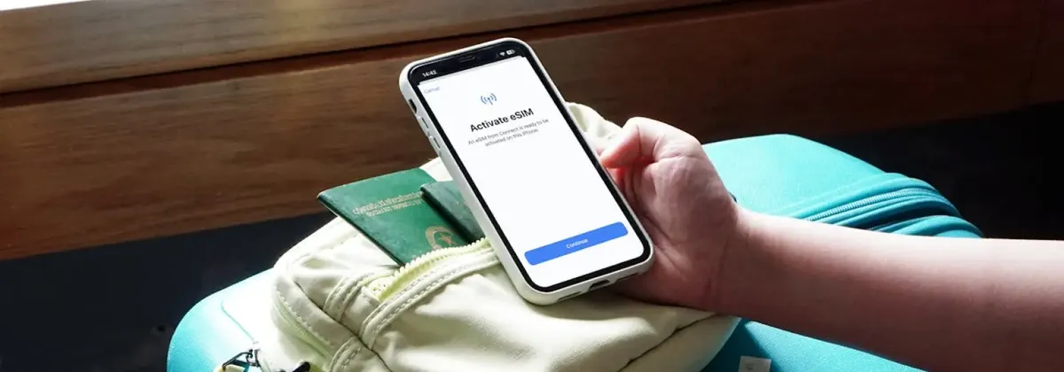 A hand holding a phone and using a travel eSIM