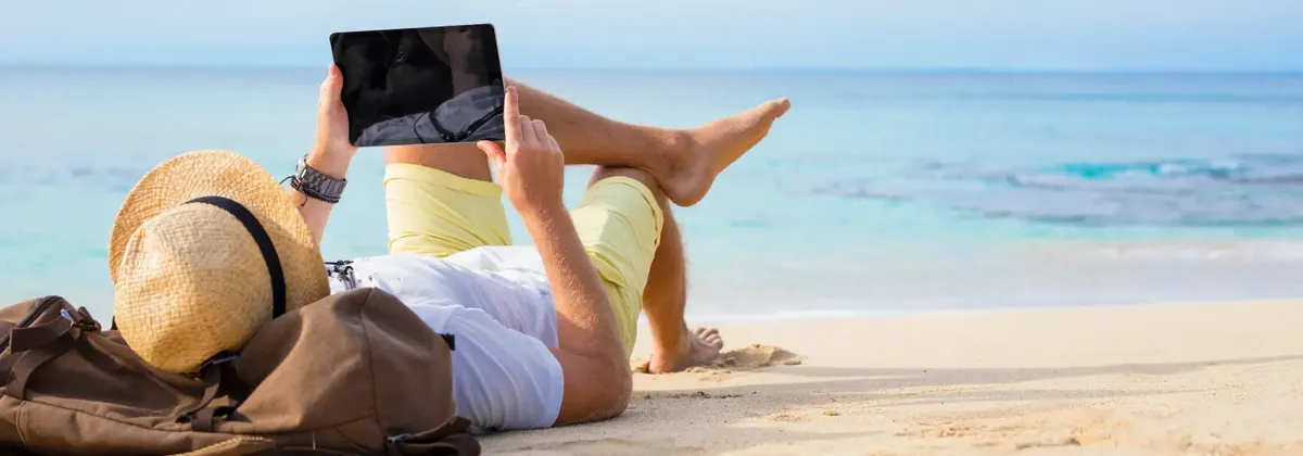 Connectivity in Summer - a person lies on the shore on a beach reading