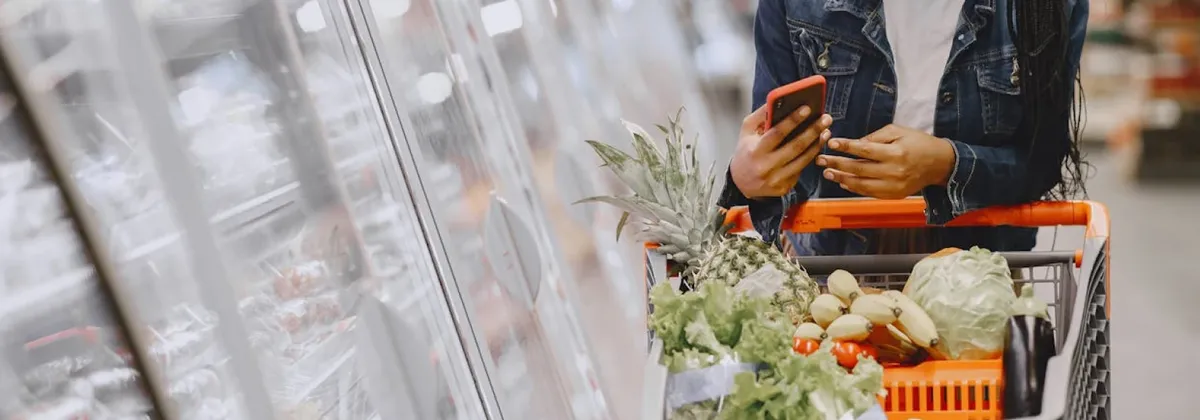 A person using their phone in a supermarket