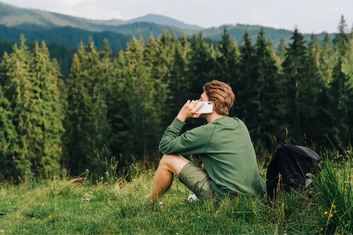A person using an eSIM phone while in a forest