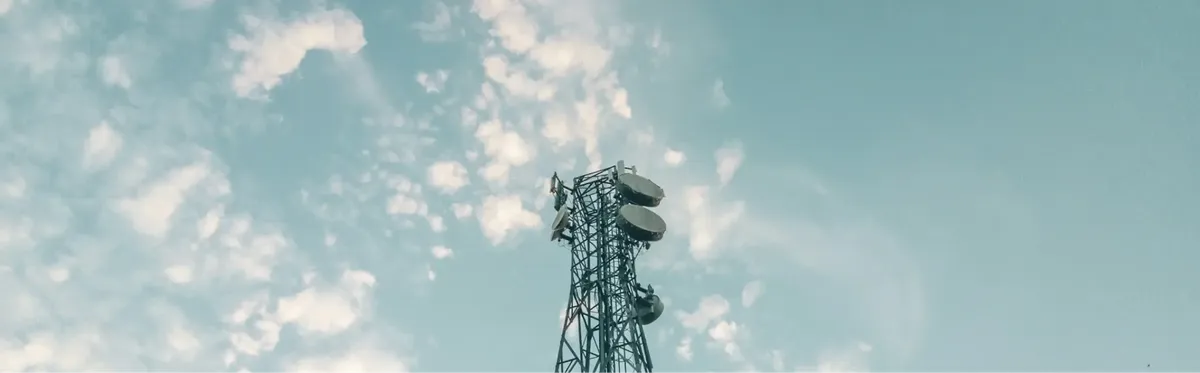 A cell tower in front of a blue sky