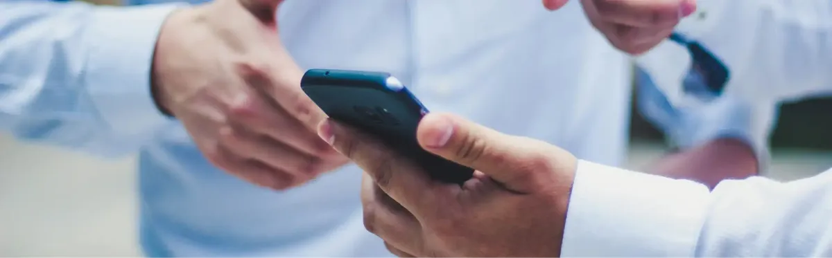 Two people using a phone with Message+ to conduct business