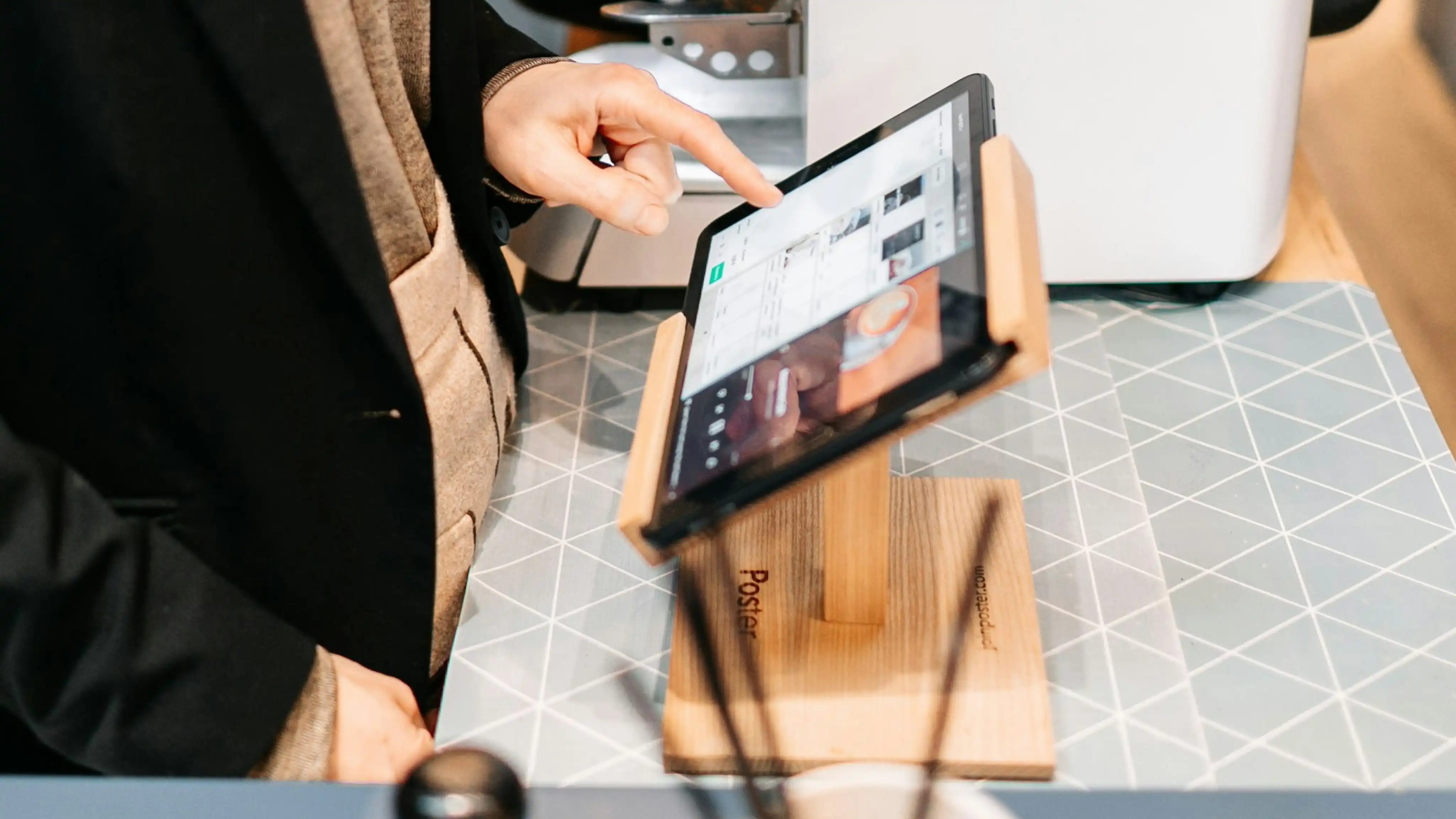 A person using a touchscreen POS to confirm a transaction in a store
