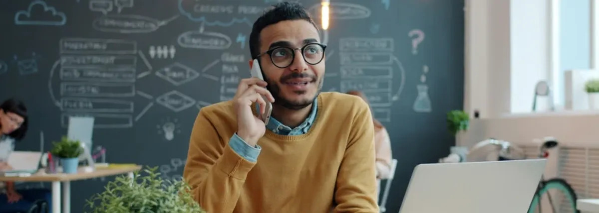 BYOD fatigue - an office worker speaks on a mobile phone while seated at their desk