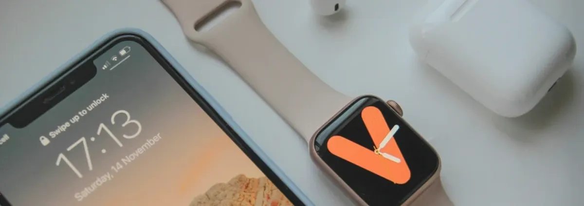 OS-level changes - iPhone, Apple Watch and Airpods lined up on a white surface