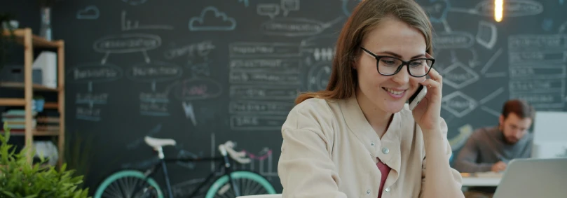 Embedded Telco - a woman using a mobile phone plan in her modern office