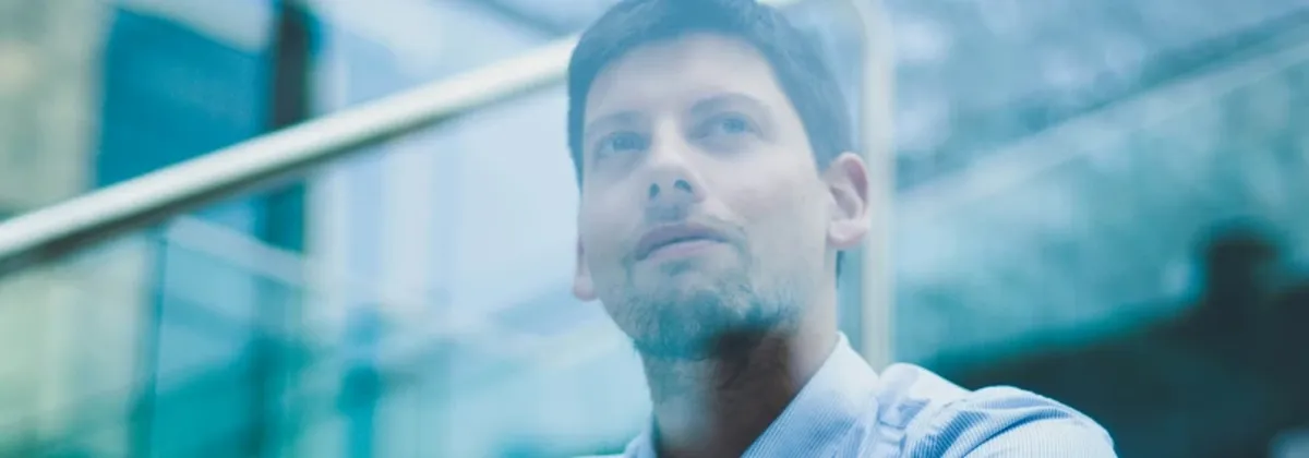 Future of Corporate Connectivitiy - businessman sits on steps outside high rise office