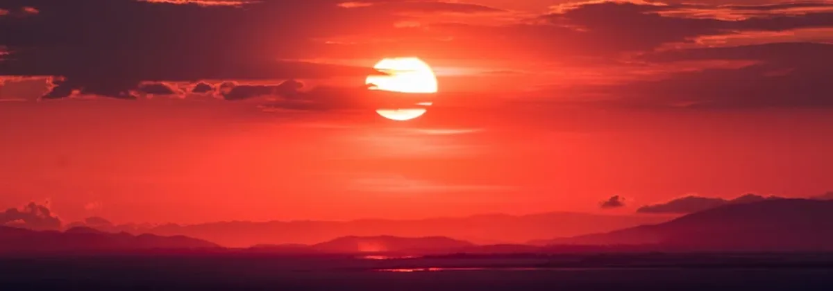 2G and 3G sunsetting for IoT - a dark red sunset over a wide landscape