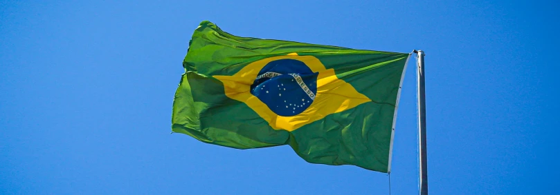 Brazil Compliance Regulations - The Brazilian flag against a blue sky