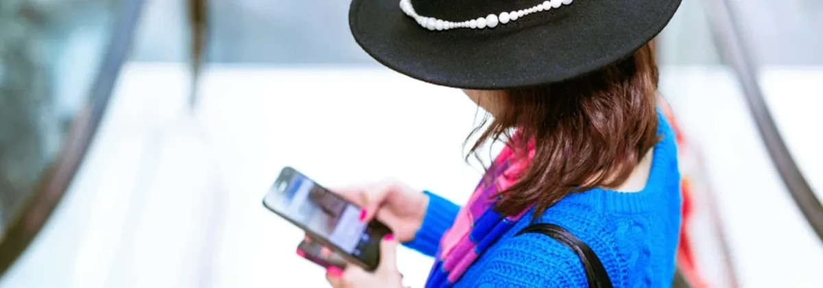 The Future of Roaming - a female traveler using a mobile phone at an airport
