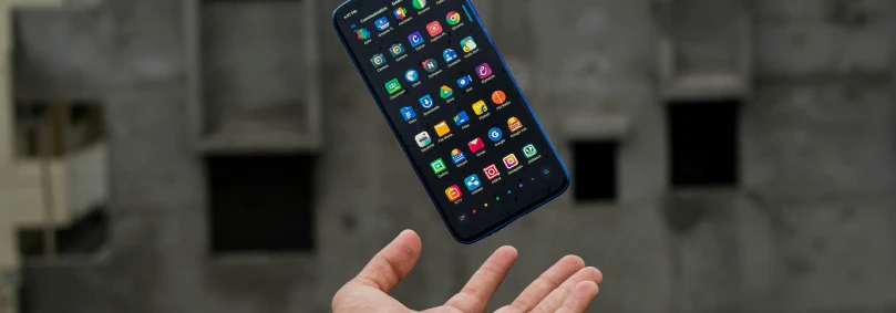 Resellers and RSP - A hand tossing a mobile phone that has a full screen of apps