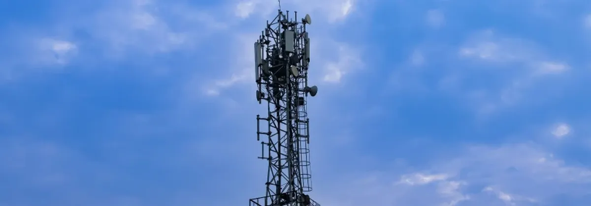 Consistent IoT Connectivity - a mobile tower against a dark blue sky