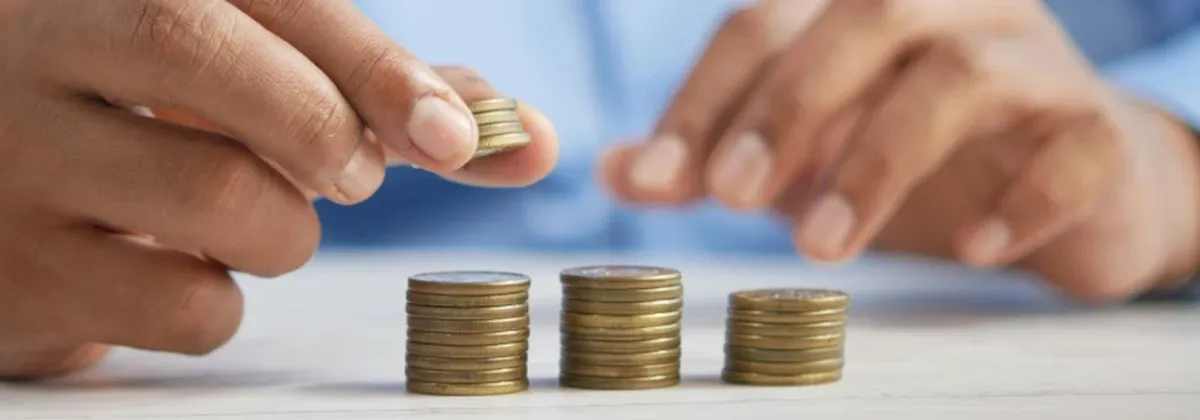 Entitlement Server - hands stacking piles of coins on a white surface