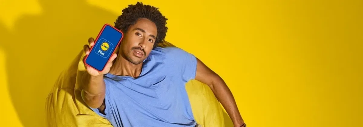 1GLOBAL and Lidl - man holding a mobile phone against a yellow backdrop