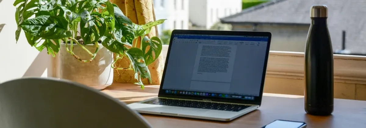Remote Work - a home office set up with laptop, phone and water bottle