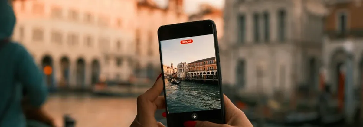 Consumer eSIM in 2026 - A traveler uses their mobile phone to take a picture of Venice