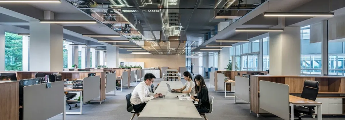 Smart buildings with next-gen IoT - a modern open plan office wtih people working in the middle
